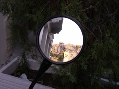 the Acropolis seen in a motorcycle's mirror